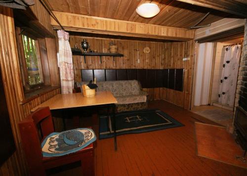 an inside view of a cabin with a table and a bench at Likimo ratas in Paliepis