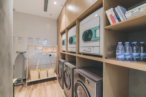 a laundry room with a washer and dryer on a shelf at Atour Hotel Xuzhou City Hall in Xuzhou