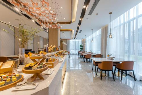 um restaurante com mesas, cadeiras e janelas em Atour Hotel Hangzhou Chongxian Banshan em Hangzhou