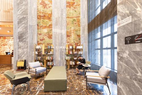 a man sitting at a table in a library at Atour X Hotel Yancheng Lingxiang Xinlong Road in Yancheng