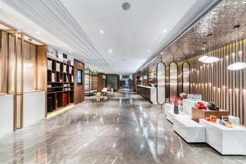een lobby van een gebouw met banken en tafels bij Atour Hotel Tongxiang South Qingfeng Road in Tongxiang