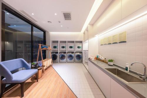 uma lavandaria com um lavatório e máquinas de lavar roupa em Atour Hotel Datong Dongxin Plaza Railway Station em Datong