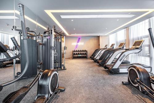 a gym with a row of treadmills and machines at Atour Hotel Wuhan International Plaza Tongji Medical College of HUST in Wuhan