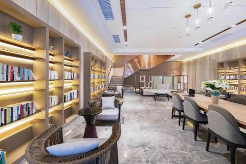 uma biblioteca com cadeiras, mesas e estantes em Atour Hotel Wuhan International Plaza Tongji Medical College of HUST em Wuhan