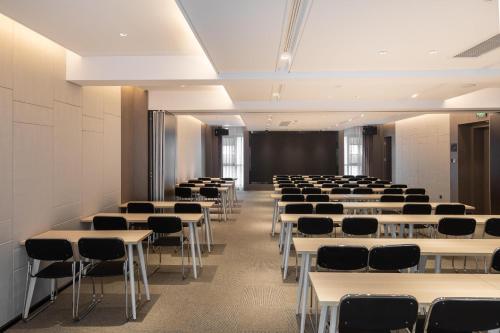 a room with rows of tables and chairs at Atour Hotel Wuhan Guanggu Qingnianhui JinRongGang in Wuhan