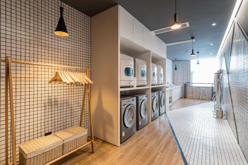 a laundry room with three washer and dryer at Atour Hotel Industrial Park Dongsha Lake in Suzhou