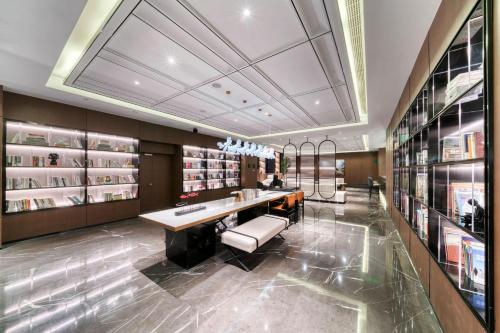 een grote kamer met een bureau en boekenplanken bij Atour Hotel Tongxiang South Qingfeng Road in Tongxiang
