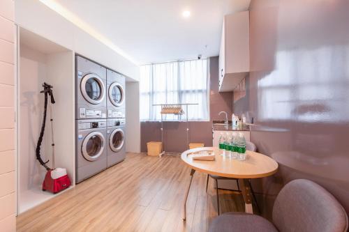 a laundry room with a table and washing machines at Atour X Hotel Yancheng Lingxiang Xinlong Road in Yancheng