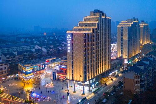 a city lit up at night with a tall building at Atour Hotel Wuhan Guanggu Qingnianhui JinRongGang in Wuhan