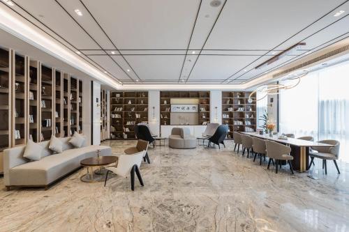 a library with couches and tables and chairs at Atour Hotel Industrial Park Dongsha Lake in Suzhou