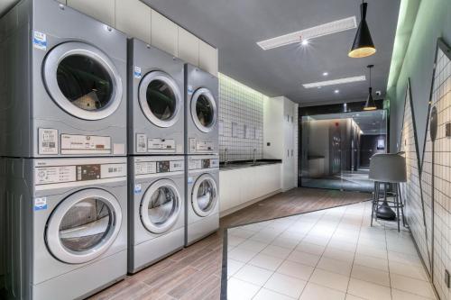 a laundry room with four washer and dryer machines at Atour Hotel Tongxiang South Qingfeng Road in Tongxiang