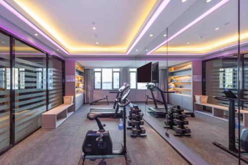 un gimnasio con equipamiento de ejercicio y una TV en una habitación en Atour Hotel Datong Dongxin Plaza Railway Station, en Datong