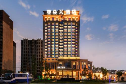 a hotel building with a sign on top of it at Atour X Hotel Yancheng Lingxiang Xinlong Road in Yancheng