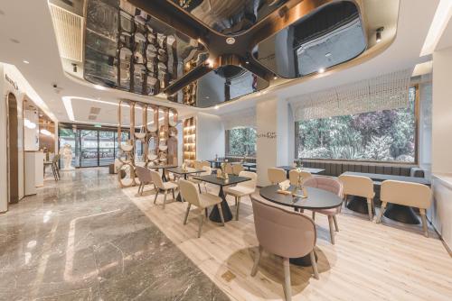 een restaurant met tafels en stoelen en een televisie aan het plafond bij Atour Light Hotel Nanjing Fuzi Temple Zhonghuamen Station in Nanjing