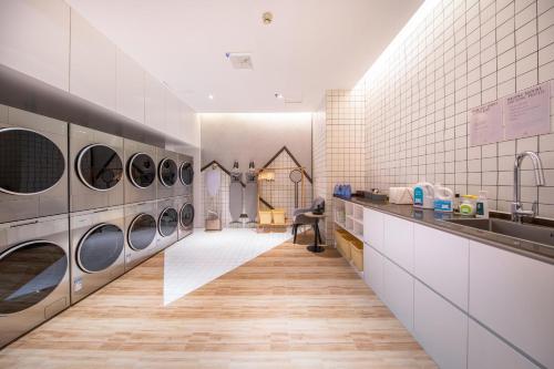a laundry room with four washer and dryer machines at Atour Hotel Wuhan Chuhehanjie Wuhan University in Wuhan