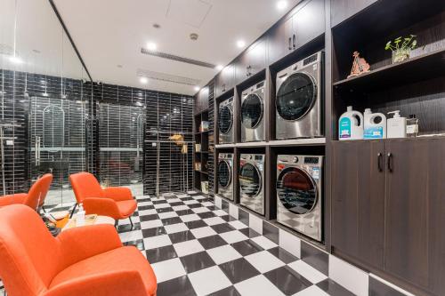a laundry room with orange chairs and a checkered floor at Atour Hotel Shaoxing Jinghu City Hall Basketball Theme in Shaoxing