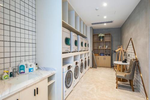 a laundry room with three washer and dryer machines at Atour Hotel Wuhan International Plaza Tongji Medical College of HUST in Wuhan
