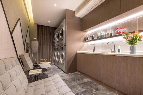 y baño con lavabo y lavadora. en Atour Hotel Wuhan Guanggu Qingnianhui JinRongGang en Wuhan