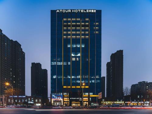 a tall building in a city at night at Atour Hotel Xuzhou CBD in Xuzhou