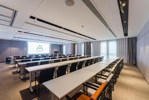 a lecture hall with tables and chairs and a screen at Atour Hotel Nanjing Xianlin Center Jinying Plaza in Nanjing