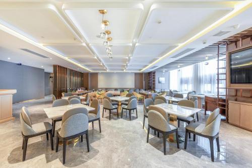 um restaurante com mesas e cadeiras num quarto em Atour Hotel Wuhan International Plaza Tongji Medical College of HUST em Wuhan