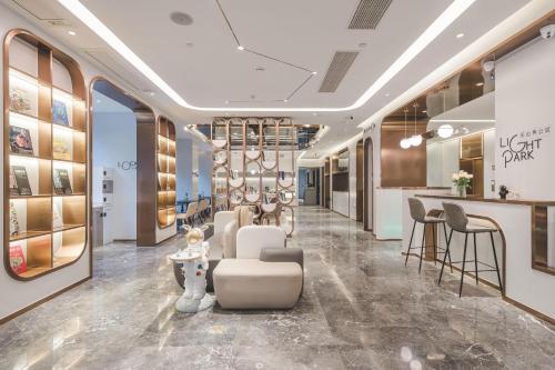 a lobby with a salon with chairs and a bar at Atour Light Hotel Nanjing Fuzi Temple Zhonghuamen Station in Nanjing