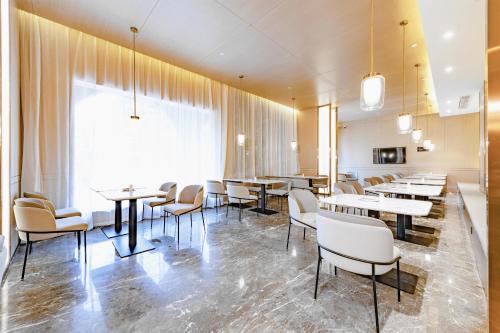 a restaurant with tables and chairs and a large window at Atour Hotel Guilin City Hall in Guilin