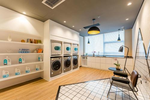 a laundry room with three washer and dryer at Atour Hotel Xuzhou CBD in Xuzhou