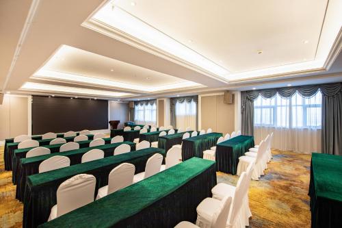 uma sala de conferências com cadeiras verdes e brancas e um quadro-negro em Atour X Hotel Yancheng Lingxiang Xinlong Road em Yancheng