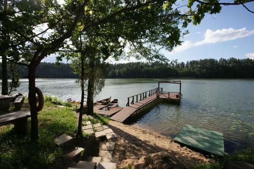 a dock on a lake with two benches on it at Likimo ratas in Paliepis