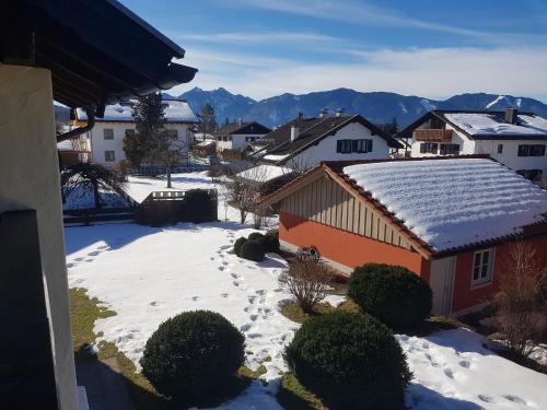 uma aldeia coberta de neve com montanhas ao fundo em La Locanda Ristorante Pizzeria Garni em Ohlstadt
