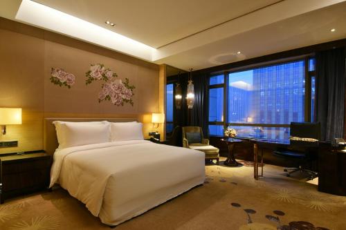 a bedroom with a white bed and a desk and a computer at InterContinental Shijiazhuang by IHG in Shijiazhuang