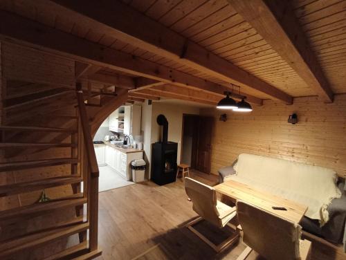 a room with a table and chairs and a kitchen at Domek w Cisnej pod Honem 2 in Cisna