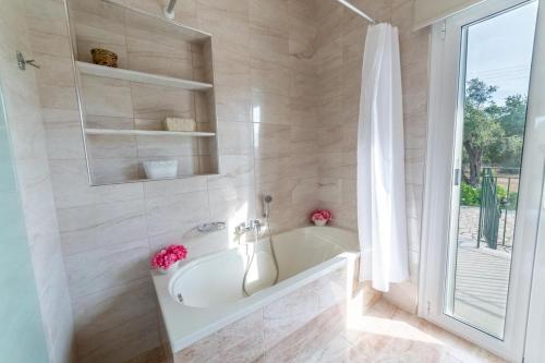 a white bathroom with a tub and a shower at Villa Adonis in Halikounas