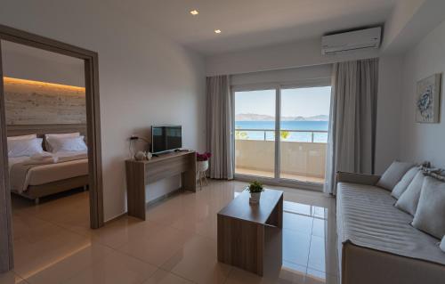 a hotel room with a couch and a bed and a window at Orpheus Studios in Kos Town