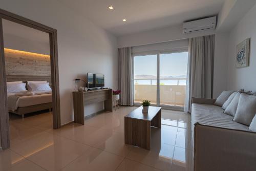 a living room with a couch and a bed and a television at Orpheus Studios in Kos Town