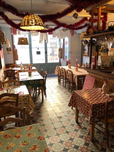 een restaurant met tafels en stoelen in een kamer bij Le Boustrophédon in Antraigues