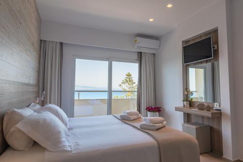 a bedroom with a large bed with a large window at Orpheus Studios in Kos Town