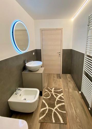 a bathroom with a sink and a toilet and a mirror at RESIDENZA IL RICCIO in Andalo