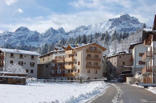 a town in the snow with mountains in the background at RESIDENZA IL RICCIO in Andalo