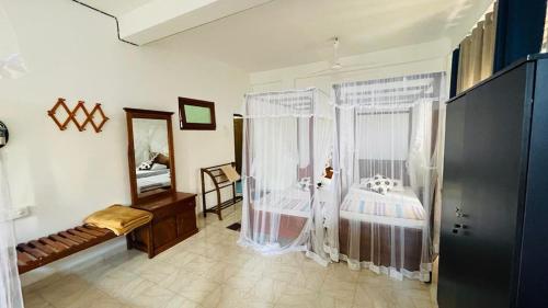 ein Schlafzimmer mit Dusche und ein Bett mit Vorhängen in der Unterkunft Sunny Mood Guest House in Unawatuna