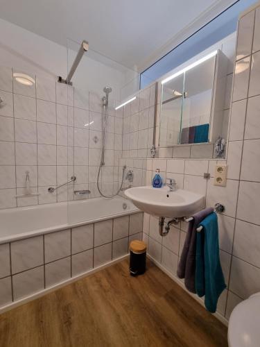 a bathroom with a sink and a shower and a tub at Ferienwohnung Ruske in Friedrichshafen