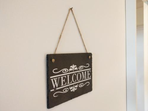 a sign that says welcome hanging on a door at Ferienwohnung Simonhöhe in Zirkitz