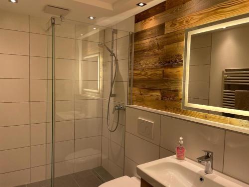 a bathroom with a glass shower and a sink at Ferienwohnung Oberallgäu Ferienpark mit Schwimmbad in Missen-Wilhams