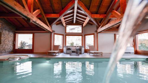 a swimming pool in a house with a large ceiling at Chalet Hôtel des 2 Gares in Saint-Gervais-les-Bains