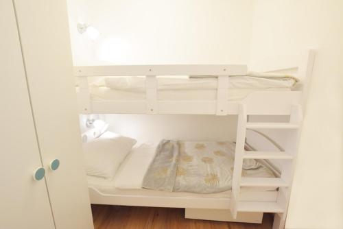 a small white bunk bed in a white room at Ferienwohnung Simonhöhe in Zirkitz
