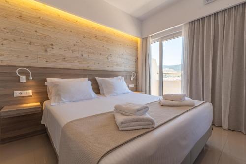 a bed with a white comforter and pillows at Orpheus Studios in Kos