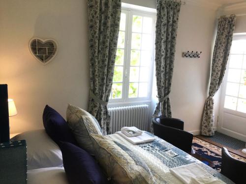 a bedroom with a bed and windows with a heart on the wall at Vue du Château d'Excideuil en chambres in Excideuil