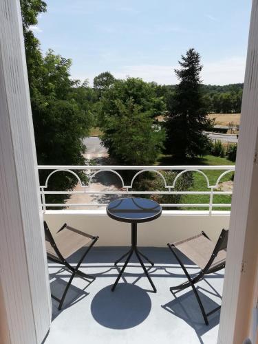 a patio with a table and chairs on a balcony at Vue du Château d'Excideuil en chambres in Excideuil