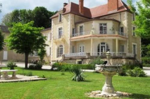 a large house with a fountain in the yard at Vue du Château d'Excideuil en chambres in Excideuil